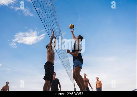 Teams mit multinationalen Spielern spielen im Sommer Beachvolleyball am Strand in Vietnam. Nha Trang, Vietnam - 4. August 2024 Stockfoto