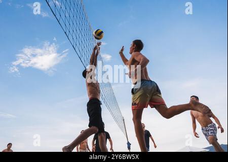 Teams mit multinationalen Spielern spielen im Sommer Beachvolleyball am Strand in Vietnam. Nha Trang, Vietnam - 4. August 2024 Stockfoto