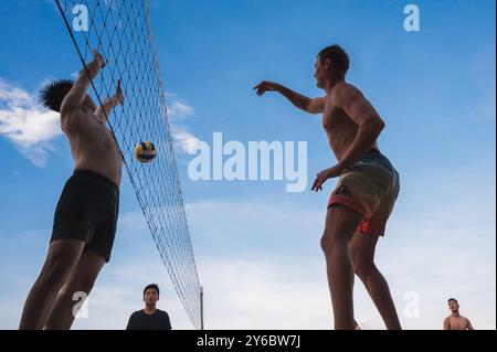 Teams mit multinationalen Spielern spielen im Sommer Beachvolleyball am Strand in Vietnam. Nha Trang, Vietnam - 4. August 2024 Stockfoto