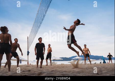 Teams mit multinationalen Spielern spielen im Sommer Beachvolleyball am Meer in Nha Trang in Asien. Nha Trang, Vietnam - 4. August 2024 Stockfoto