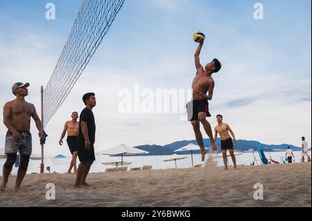 Teams mit multinationalen Spielern spielen im Sommer Beachvolleyball am Strand am Meer in Vietnam. Nha Trang, Vietnam - 4. August 2024 Stockfoto