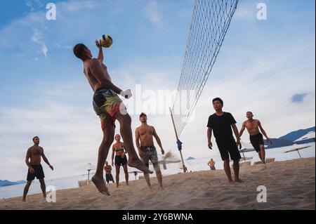 Teams mit multinationalen Spielern spielen Beachvolleyball am Meer in Nha Trang in Asien. Nha Trang, Vietnam - 4. August 2024 Stockfoto