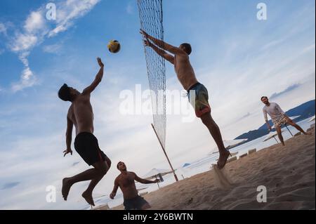 Teams mit multinationalen Spielern spielen im Sommer Beachvolleyball am Strand am Meer in Vietnam. Nha Trang, Vietnam - 4. August 2024 Stockfoto
