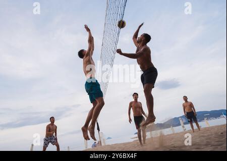 Teams mit multinationalen Spielern spielen im Sommer Beachvolleyball am Meer in Nha Trang in Asien. Nha Trang, Vietnam - 4. August 2024 Stockfoto