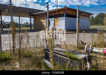 Inaktive und verlassene Tankstelle, inaktive Spender, verschobene Fenster, umzäunter Bereich, alter Bahnhof im Stadtzentrum an der Schnellstraße Stockfoto