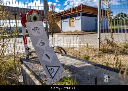 Inaktive und verlassene Tankstelle, inaktive Spender, verschobene Fenster, umzäunter Bereich, alter Bahnhof im Stadtzentrum an der Schnellstraße Stockfoto