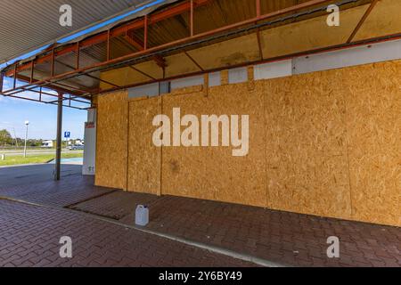 Inaktive und verlassene Tankstelle, inaktive Spender, verschobene Fenster, umzäunter Bereich, alter Bahnhof im Stadtzentrum an der Schnellstraße Stockfoto