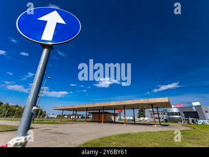 Inaktive und verlassene Tankstelle, inaktive Spender, verschobene Fenster, umzäunter Bereich, alter Bahnhof im Stadtzentrum an der Schnellstraße Stockfoto