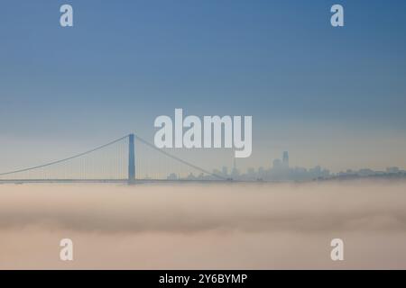 Golden Gate Bridge über Nebel mit der Skyline der Stadt in der Ferne an sonnigen Tagen Stockfoto