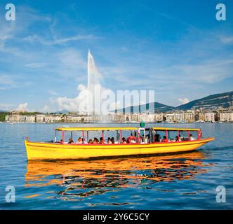 Der Jet d'eau und ein Schiff der Mouettes Genevoises bei Sonnenschein und blauem Himmel auf dem Lake Leman. Kanton Genf, Schweiz Stockfoto