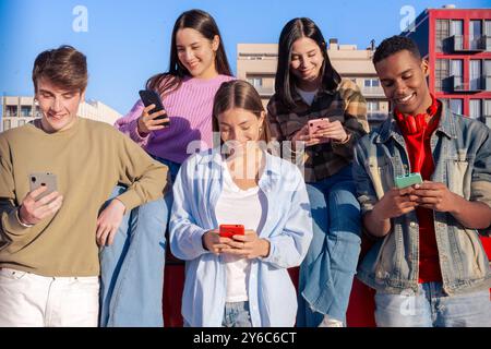 Schüler, die Spaß mit Mobiltelefonen haben, um Inhalte in sozialen Medien zu erstellen. Stockfoto