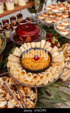 Eine köstliche Auswahl an Vorspeisen und Desserts auf einem Tisch, mit einer Auswahl an Gebäck, Dips und Kuchen. Stockfoto