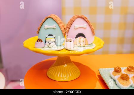Farbenfrohe Cupcakes mit Hundespielen und Hundespielen auf einem gelben Kuchenständer. Stockfoto