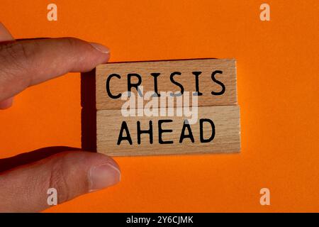 Krisenbotschaft auf Holzblöcken auf orangefarbenem Hintergrund. Konzeptionelles Krisensymbol. Kopierbereich. Stockfoto