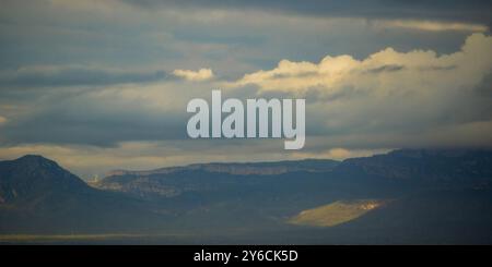 Windturbinen und das Wolkenmeer auf blauen Bergen im Hintergrund bieten einen Panoramablick auf die wunderschöne Naturlandschaft Stockfoto