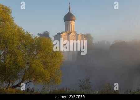 Die mittelalterliche Fürbitte-Kirche auf dem Nerl im Nebel an einem sonnigen Septembermorgen. Bogolyubovo, der Goldene Ring Russlands Stockfoto