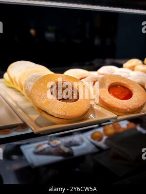 Eine Auswahl an verschiedenen Gebäckstücken, einschließlich Keksen und Donuts. Die Kekse sind mit Puderzucker bedeckt und die Donuts glasiert Stockfoto