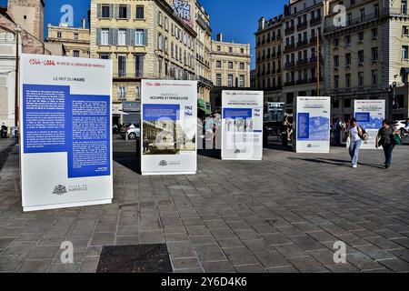 Marseille, Frankreich. September 2024. Zwei Frauen werden am Quai de la Fraternité in Marseille an der Gedenkausstellung zum 80. Jahrestag der Befreiung von Marseille vorbeilaufen sehen. Anlässlich der Gedenkfeier zum 80. Jahrestag der Befreiung von Marseille erzählt eine Gedenkausstellung in Form von Würfeln auf dem Quai de la Fraternité (Vieux-Port) Episoden der Rückeroberung der Stadt und zollt den Kämpfern von 1944 Tribut. Anlässlich der Gedenkfeier zum 80. Jahrestag der Befreiung von Marseille, eine Gedenkausstellung in der Stadt Stockfoto