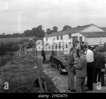 Detectives VON Scotland Yard unter der Leitung von Commander George Hatherill sind heute Nachmittag auf einem einsamen, aus Backsteinen gebauten Häuschen und Nebengebäuden auf der Leatherslade Farm, wo die ehemaligen Mieter vor etwa drei Wochen die Wohnung verlassen hatten, geschossen. Als die Pächter verließen, zogen die Räuber ein und nutzten es für ihr Hauptquartier. Hier sind Polizei und Presse am Eingang der Farm abgebildet, wo die Bande geflogen war, und sie hinterließen leere Postsäcke, aber kein Geld. Das Bauernhaus und die Nebengebäude wurden bis zum Fingerabdruck abgeschottet Stockfoto