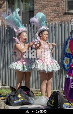 Vor dem Beginn der Hispanic Heritage Parade 2024 passen bolivianische Frauen ihre aufwendigen Kostüme in Jackson Heights, Queens, New York an. Stockfoto