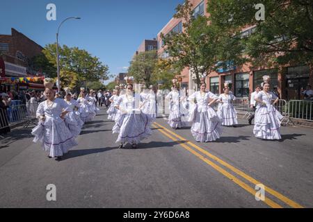 Eine Gruppe paraguayischer Frauen tanzen und marschieren in weißen Kostümen. Bei der Queens Hispanic Day Parade 2024 in Jackson Heights. Stockfoto