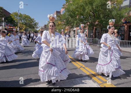 Eine Gruppe paraguayischer Frauen tanzen und marschieren in weißen Kostümen. Bei der Queens Hispanic Day Parade 2024 in Jackson Heights. Stockfoto