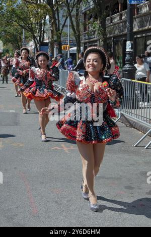 Eine glückliche peruanische junge Dame aus Amerika marschiert und tanzt in einem farbenfrohen Kostüm mit der Gruppe bei der Queens Hispanic Day Parade 2024 in Jackson Heights. Stockfoto