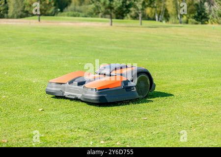 Ein automatisches Mähroboter schneidet den gut gepflegten Rasen. Landschaftsbild des Golfplatzes Stockfoto
