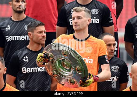 Leverkusen, Deutschland. September 2024. Leverkusener Torhüter Lukas Hradecky (M) hält die Meisterschafttrophäe während der Fotosession des deutschen Champions. Quelle: Federico Gambarini/dpa/Alamy Live News Stockfoto