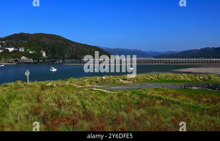 Barmouth Rail und Fußgängerbrücke mit zweiteiligem Dieselzug, der die Brücke von Fairbourne über die Mawddach Mündung überquert. Stockfoto