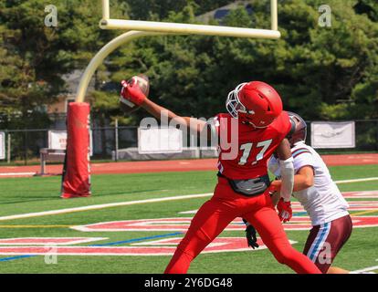 Nahaufnahme eines High School Football Wide Receivers, der während eines Fußballspiels von hinten in der Endzone einhändig auffängt. Stockfoto