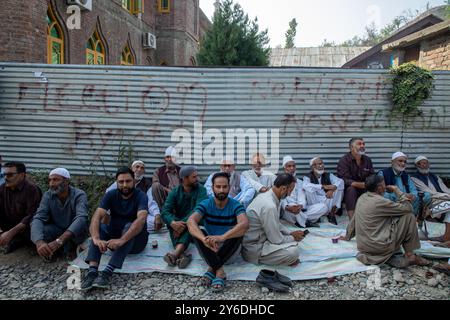 Budgam, Indien. September 2024. Kaschmir-Wähler sitzen vor einem Wahlhaus, während sie auf ihre Wahlurnen warten, um ihre Stimmzettel während der zweiten Phase der Parlamentswahlen in Jammu und Kaschmir in Budgam südwestlich von Srinagar abzugeben. Dies sind die ersten Kommunalwahlen seit einem Jahrzehnt und die ersten, seit Neu-Delhi 2019 den halbautonomen Status der Region widerrief und sie unter direkte Herrschaft stellte. Fast neun Millionen Menschen sind registriert, um in der umstrittenen Region zu wählen, die traditionell für Boykotte aus Protest gegen die indische Herrschaft bekannt ist. Quelle: SOPA Images Limited/Alamy Live News Stockfoto