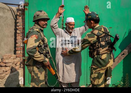 Budgam, Indien. September 2024. Ein indischer paramilitärischer Soldat frittiert einen kaschmirischen Wähler, bevor er in die Wahlstation während der zweiten Phase der Parlamentswahlen in Jammu und Kaschmir in Budgam, südwestlich von Srinagar, eindringt. Dies sind die ersten Kommunalwahlen seit einem Jahrzehnt und die ersten, seit Neu-Delhi 2019 den halbautonomen Status der Region widerrief und sie unter direkte Herrschaft stellte. Fast neun Millionen Menschen sind registriert, um in der umstrittenen Region zu wählen, die traditionell für Boykotte aus Protest gegen die indische Herrschaft bekannt ist. Quelle: SOPA Images Limited/Alamy Live News Stockfoto