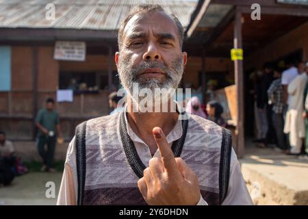 Budgam, Indien. September 2024. Ein kaschmirischer Wähler zeigt seinen Finger, nachdem er seinen Wahlzettel außerhalb des Wahlhauses während der zweiten Phase der Parlamentswahlen in Jammu und Kaschmir in Budgam, südwestlich von Srinagar, abgeworfen hat. Dies sind die ersten Kommunalwahlen seit einem Jahrzehnt und die ersten, seit Neu-Delhi 2019 den halbautonomen Status der Region widerrief und sie unter direkte Herrschaft stellte. Fast neun Millionen Menschen sind registriert, um in der umstrittenen Region zu wählen, die traditionell für Boykotte aus Protest gegen die indische Herrschaft bekannt ist. Quelle: SOPA Images Limited/Alamy Live News Stockfoto