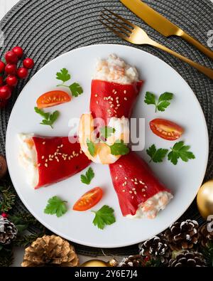 Rote Piquillo-Paprika gefüllt mit Kabeljau. Tisch mit Panoramablick und Weihnachtsdekoration. Stockfoto