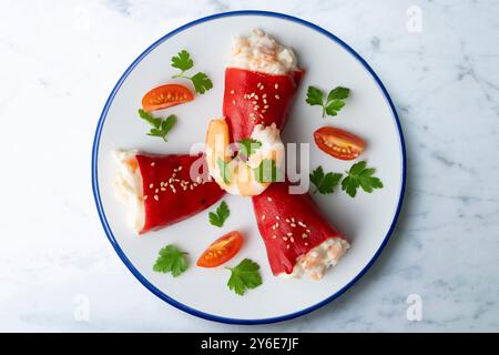 Rote Piquillo-Paprika gefüllt mit Kabeljau. Tisch mit Panoramablick und Weihnachtsdekoration. Stockfoto