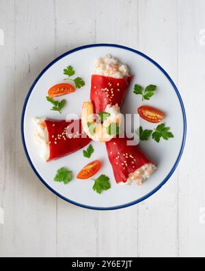 Rote Piquillo-Paprika gefüllt mit Kabeljau. Tisch mit Panoramablick und Weihnachtsdekoration. Stockfoto