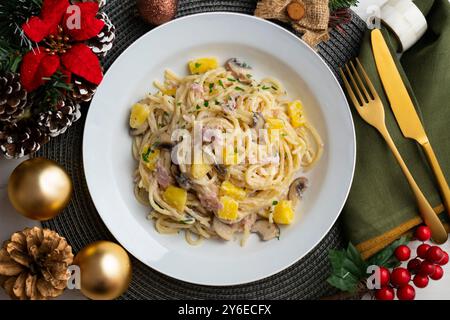 Spaghetti mit Ananas, Schinken und Sahnesauce. Tisch mit Panoramablick und Weihnachtsdekoration. Stockfoto