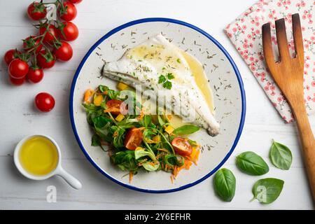 Gebackener Wolfsbarsch mit Zitronensauce. Tisch mit Blick von oben mit weihnachtsdekoration. Stockfoto