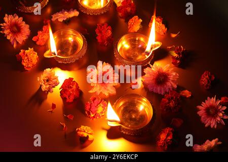 Diwali-Feier. Diya-Lampen und wunderschöne Blumen auf farbigem Hintergrund, über dem Blick Stockfoto