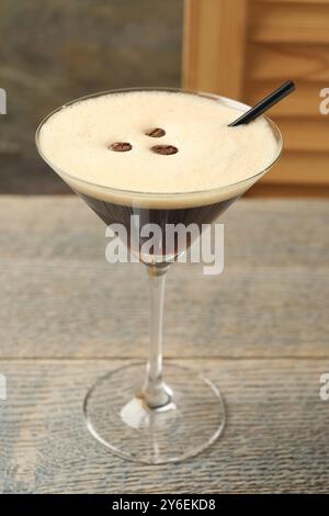 Köstlicher Espresso-Martini mit Kaffeebohnen im Glas auf Holztisch Stockfoto