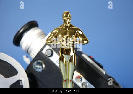 Golden Oscar Award, Videokamera und Filmrolle auf hellblauem Hintergrund, Nahaufnahme Stockfoto