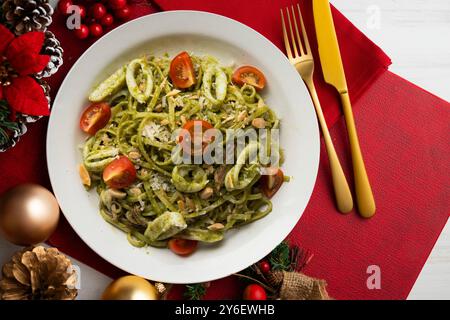 Italienische Nudeln mit Pesto-Sauce und Tintenfisch. Tisch mit Panoramablick und Weihnachtsdekoration. Stockfoto