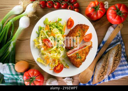 Asturischer Cachopo. Paniertes Rinderfilet gefüllt mit Käse und Pfeffer. Tisch mit Draufsicht und Dekoration. Stockfoto