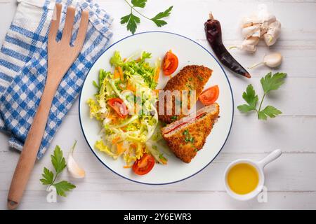 Asturischer Cachopo. Paniertes Rinderfilet gefüllt mit Käse und Pfeffer. Tisch mit Draufsicht und Dekoration. Stockfoto