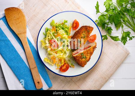 Asturischer Cachopo. Paniertes Rinderfilet gefüllt mit Käse und Pfeffer. Tisch mit Draufsicht und Dekoration. Stockfoto