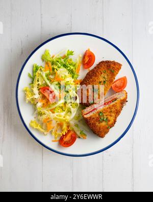 Asturischer Cachopo. Paniertes Rinderfilet gefüllt mit Käse und Pfeffer. Tisch mit Draufsicht und Dekoration. Stockfoto