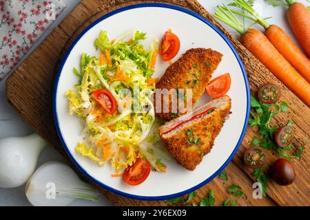 Asturischer Cachopo. Paniertes Rinderfilet gefüllt mit Käse und Pfeffer. Tisch mit Draufsicht und Dekoration. Stockfoto