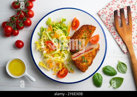 Asturischer Cachopo. Paniertes Rinderfilet gefüllt mit Käse und Pfeffer. Tisch mit Draufsicht und Dekoration. Stockfoto