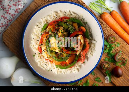 Wok von Hähnchenstreifen mit Paprika und Reis. Tisch mit Draufsicht und Dekoration. Stockfoto